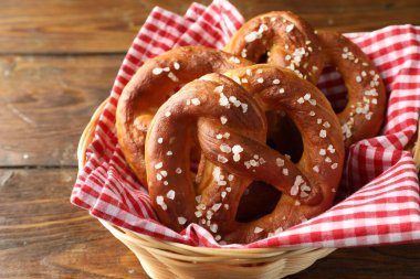 Hasır sepetteki tuzlu krakerler ahşap masada, yakın plan.
