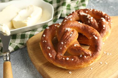Açık gri masada tuz ve tereyağlı lezzetli krakerler, yakın plan.