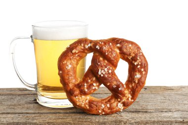 Lezzetli kraker ve bir bardak bira beyaz arka plana karşı ahşap masada.