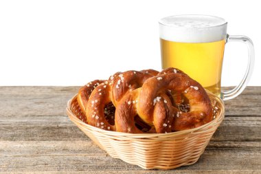 Lezzetli krakerler ve beyaz arka plana karşı ahşap masada bir bardak bira.