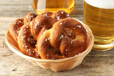 Sepette lezzetli krakerler ve ahşap masada bir bardak bira, yakın plan.