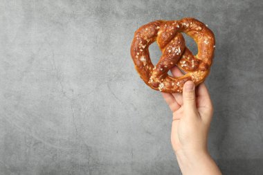 Gri desenli duvarın yanında lezzetli krakerli bir kadın, yakın plan. Metin için boşluk