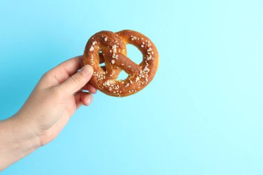 Açık mavi arka planda lezzetli krakerli kadın, yakın plan. Metin için boşluk