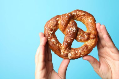 Açık mavi arka planda lezzetli krakerli kadın, yakın plan.