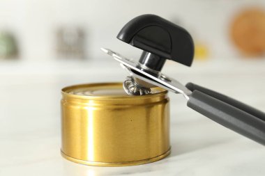 Konserve açacağı ve teneke kutu beyaz mermer masada, yakın plan.