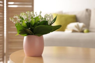 Bir buket güzel vadi zambağı kahve masasının üstünde.