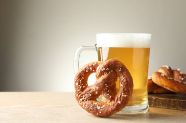 Gri arka planda lezzetli krakerler ve bir bardak bira, yakın plan. Metin için boşluk