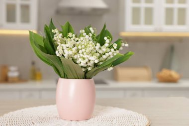 Mutfaktaki ahşap masanın üzerinde güzel bir zambak buketi.