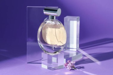 Mor arka planda parfüm şişesi ve leylak çiçeklerinin şık sunumu, yakın plan