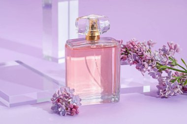 Mor arka planda parfüm şişesi ve leylak çiçeklerinin şık sunumu, yakın plan.