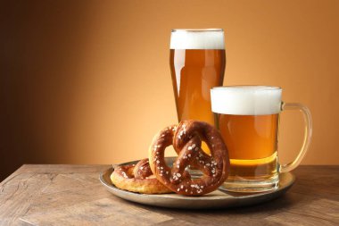 Lezzetli krakerler ve bira ahşap masada altın eğimli arka planda, yakın plan