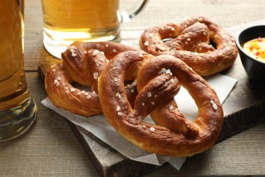 Lezzetli krakerler ve bira ahşap masada, yakın plan.