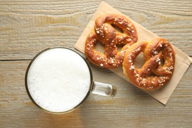 Lezzetli krakerler ve cam bardak biralar ahşap masada, düz yerde.