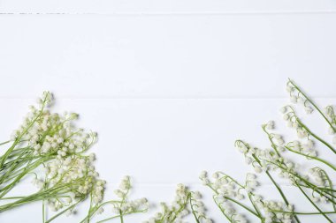 Beyaz ahşap arka planda, vadideki güzel zambak çiçekleri. Metin için boşluk