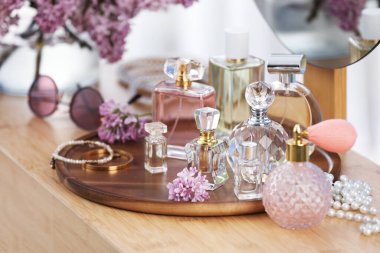 Parfümlü şişeler, leylak çiçekleri ve kapalı soyunma odasındaki aksesuarlar.