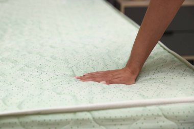 Yatakta yumuşak yatağa dokunan kadın, yakın plan.