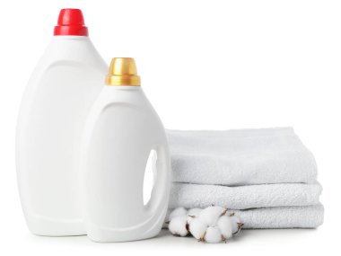 Kumaş yumuşatıcı şişeleri, yığılmış havlular ve beyaz üzerine izole edilmiş pamuk çiçekleri.