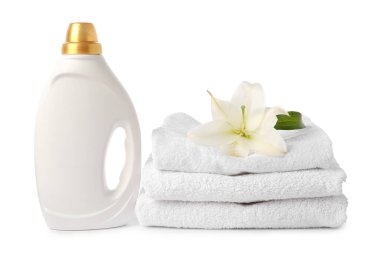 Bir şişe yumuşatıcı, istiflenmiş havlular ve beyaz üzerine izole edilmiş çiçek.