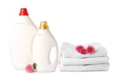 Yumuşatıcı şişeler, beyaz üzerine izole edilmiş havlular ve çiçekler.