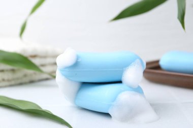 Beyaz masadaki köpüklü sabun çubukları, yakın plan.