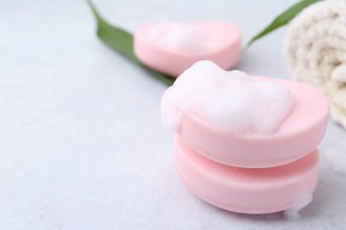 Beyaz masadaki köpüklü sabun çubukları, yakın plan. Metin için boşluk