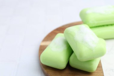 Beyaz masadaki köpüklü sabun çubukları, yakın plan. Metin için boşluk