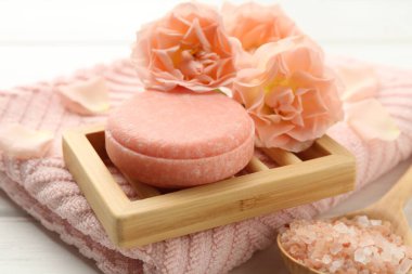 Sabun barı, deniz tuzu ve güzel çiçekler masada, yakın plan.