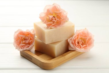 Sabun çubukları ve beyaz ahşap masada güzel çiçekler, yakın plan.