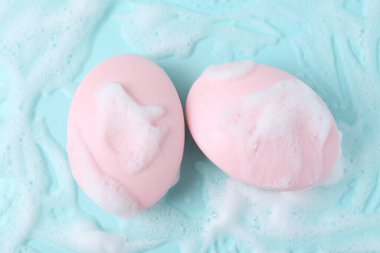 Açık mavi arka planda köpüklü sabun çubukları, düz uzanma