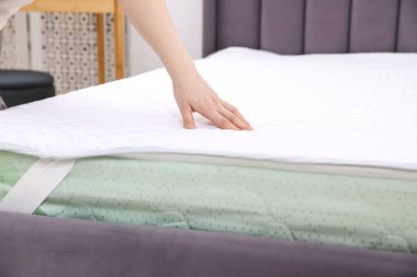 Yatakta yumuşak yatağa dokunan kadın, yakın plan.