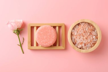 Sabun, deniz tuzu ve pembe arka planda güzel bir gül.