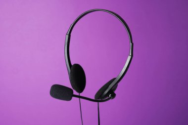 Mor arka planda mikrofonlu kulaklık.
