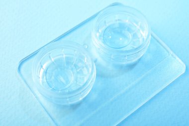 Açık mavi arkaplanda kontak lensli dosya, yakın plan