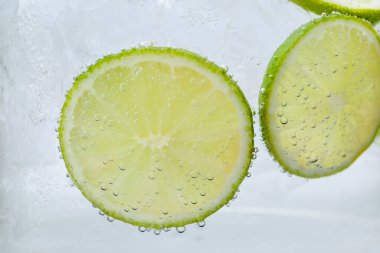 Kola suyunu limon dilimleri ve beyaz arka planda buzla tazeliyorum. Yakın plan.