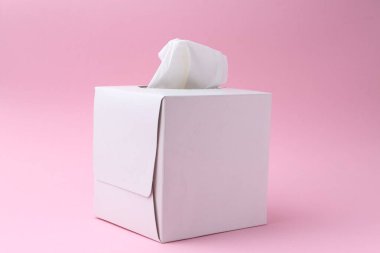 Pembe arka planda kağıt mendilli bir kutu.