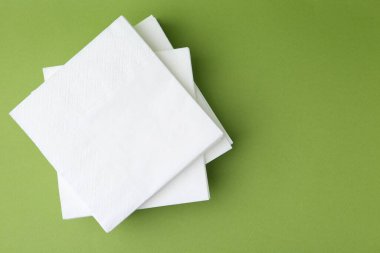 Yeşil arka planda beyaz mendil yığını, üst manzara. Metin için boşluk