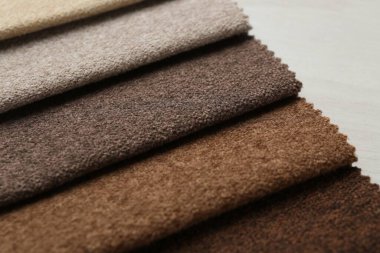 Açık ahşap masadaki farklı kumaşlardan örnekler.