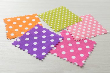 Beyaz ahşap masadaki farklı kumaşlardan örnekler, yakın plan.