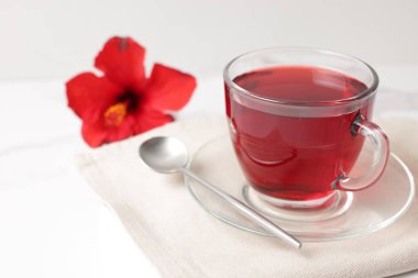 Cam bardakta leziz amber çayı ve beyaz masada kaşık, yakın plan. Metin için boşluk