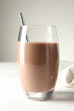 Lezzetli çikolatalı süt beyaz ahşap masada, yakın plan.