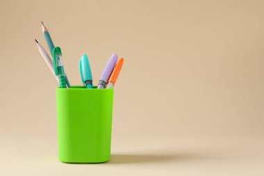 Kalemler ve kalemler bej arka planda. Metin için boşluk