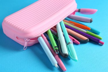 Açık mavi arkaplan üzerindeki kalemler ve kalemler, yakın plan