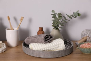 Temiz waffle havluları ve diğer banyo ürünleri ahşap şifoniyerde.