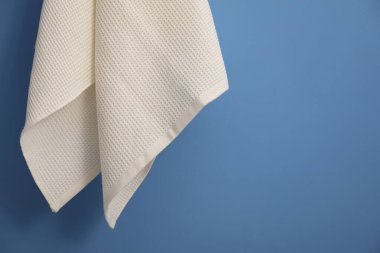 Mavi duvara asılı temiz waffle havlusu, yakın plan. Metin için boşluk