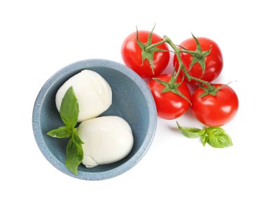 Beyaz arka planda lezzetli mozzarella peynir topları, domates ve fesleğen.