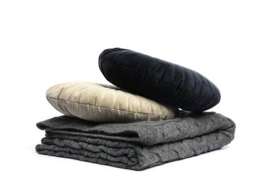 Katlanmış gri battaniye ve beyaz yastıklar