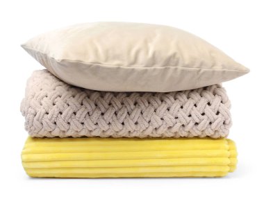 Katlanmış yün battaniye ve yastık beyaza izole edilmiş.