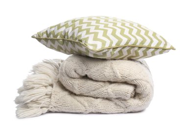 Katlanmış yün battaniye ve yastık beyaza izole edilmiş.