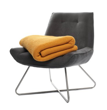 Beyaz üzerinde battaniyesi olan rahat bir koltuk.