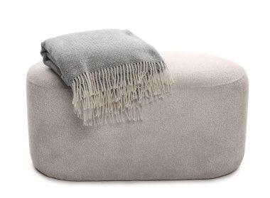 Beyaz üzerine katlanmış battaniyeli puf.